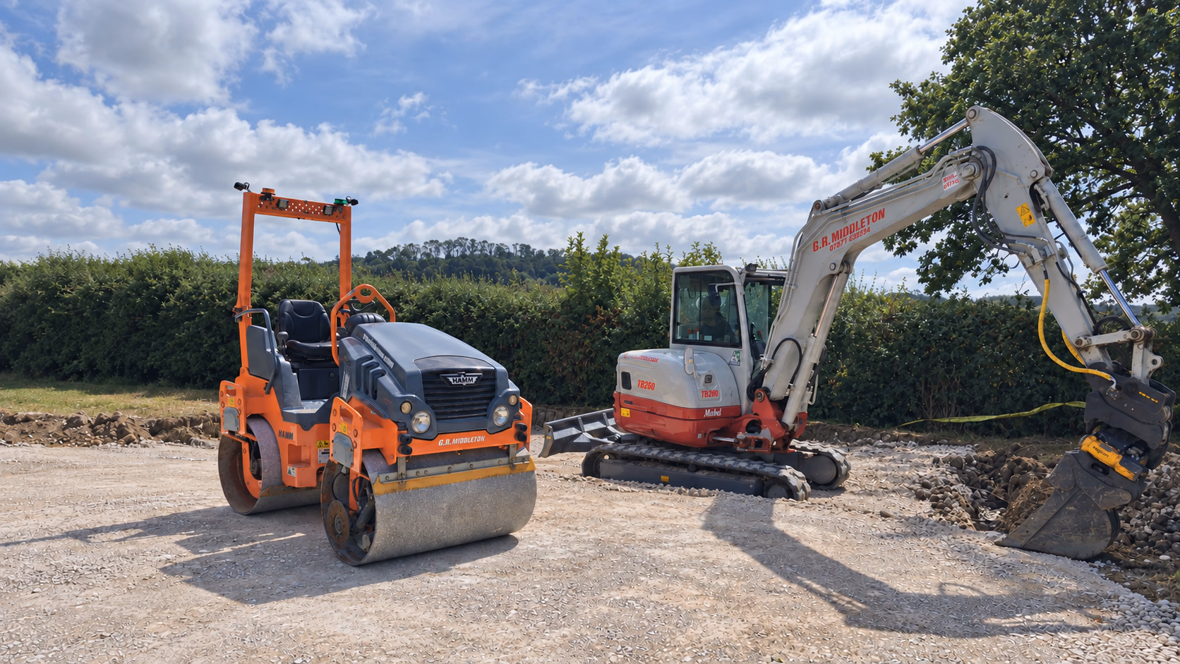 Excavator and roller preparing and compacting a stone base