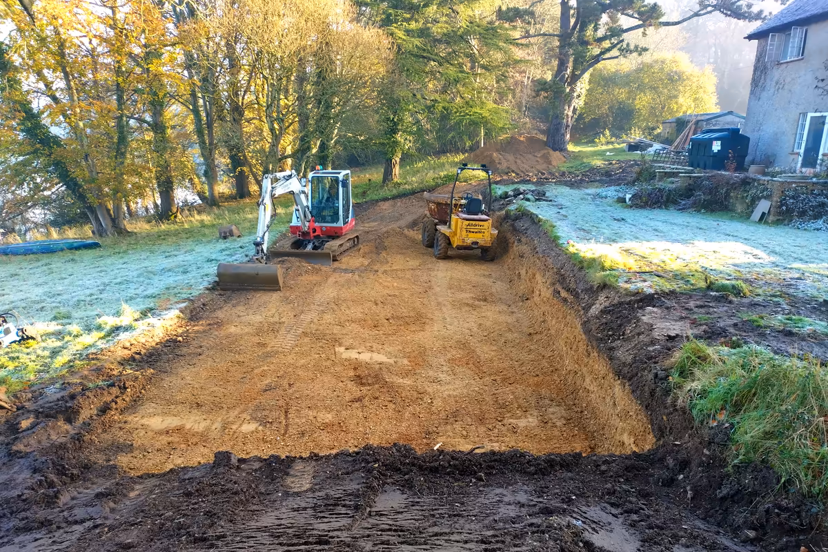 Excavator and dumper stripping and levelling a site