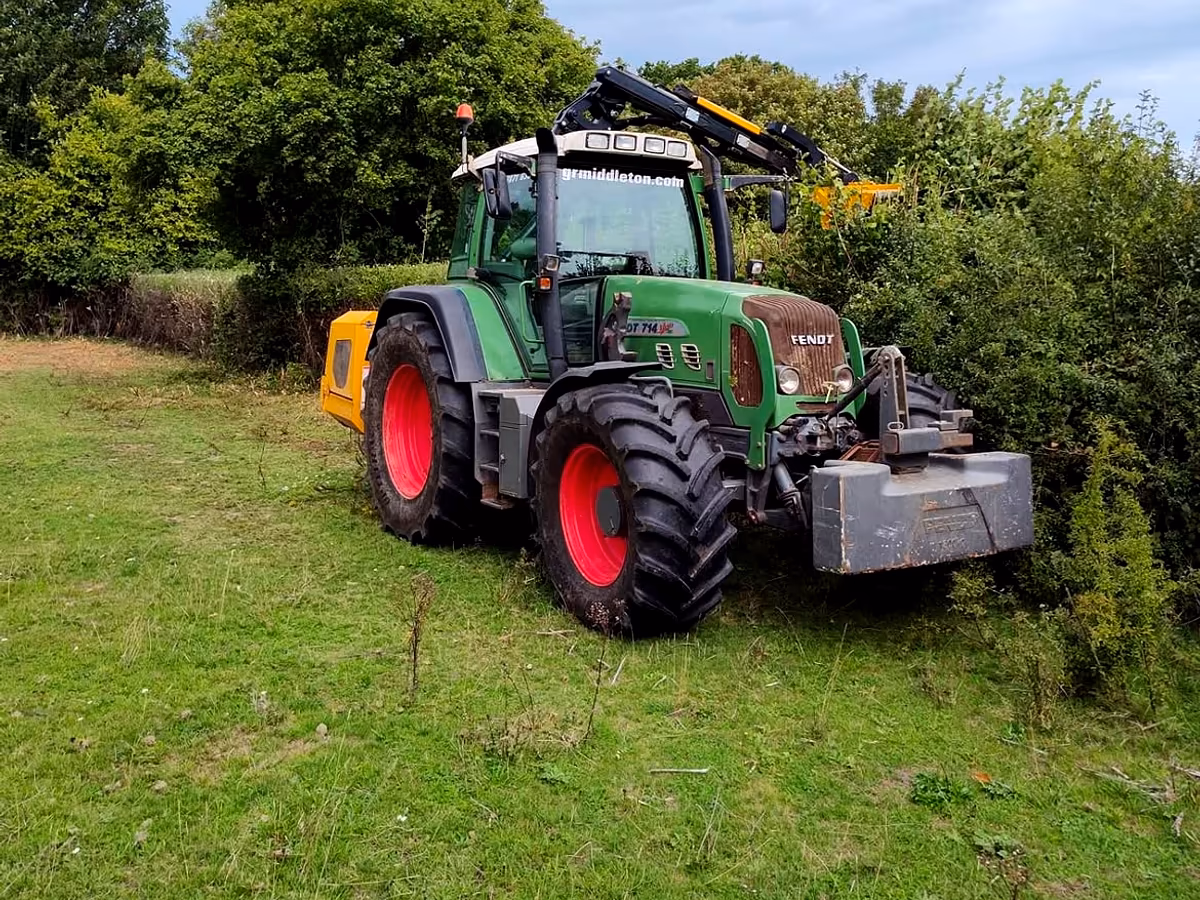 Gabriel's Fendt tractor with a hedge cutter, parked in a field beside a freshly cut hedge